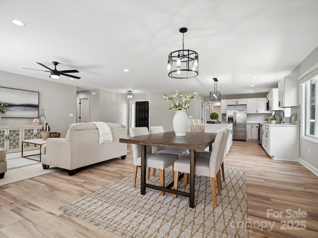 dining space featuring recessed lighting, ceiling fan with notable chandelier, and light wood-type flooring
