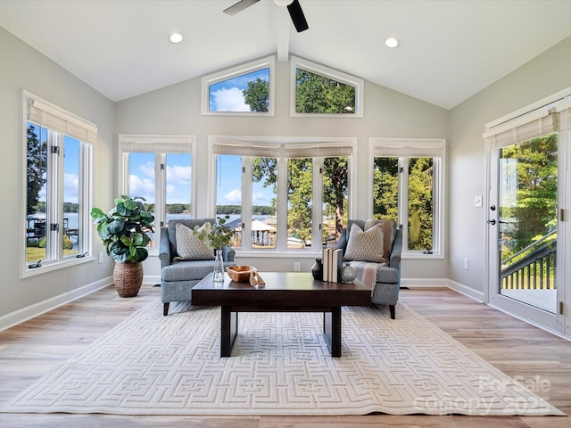 sunroom with baseboards, lofted ceiling, wood finished floors, and recessed lighting
