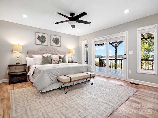bedroom featuring multiple windows, wood finished floors, access to exterior, and visible vents