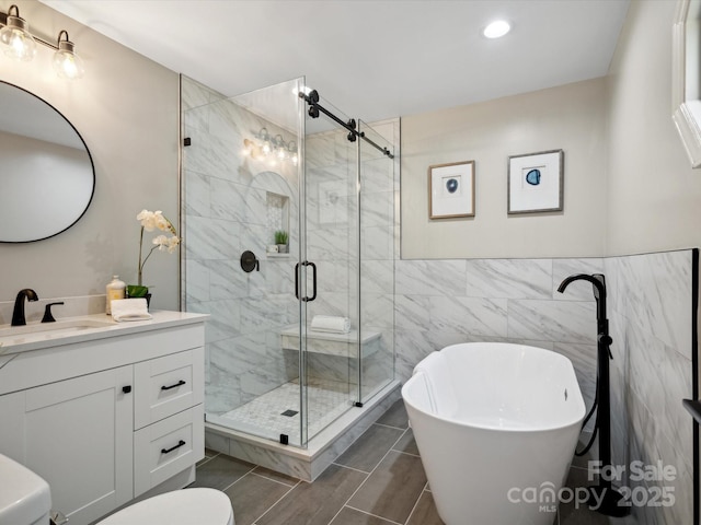 full bath featuring tile walls, toilet, a freestanding tub, vanity, and a stall shower