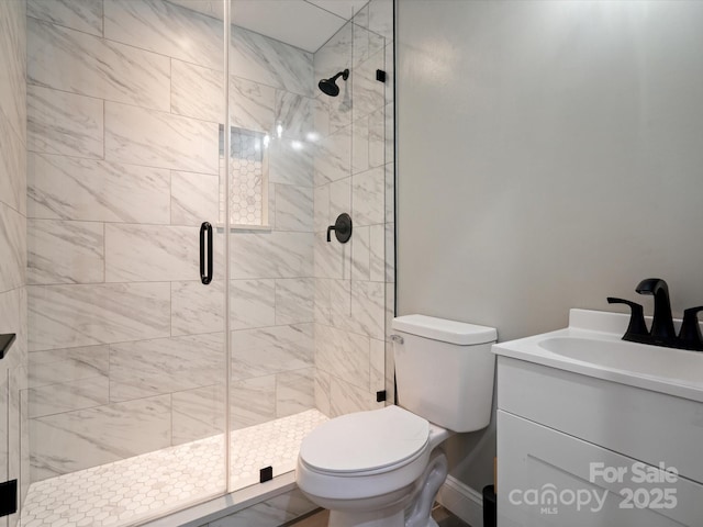 bathroom with a stall shower, toilet, and vanity