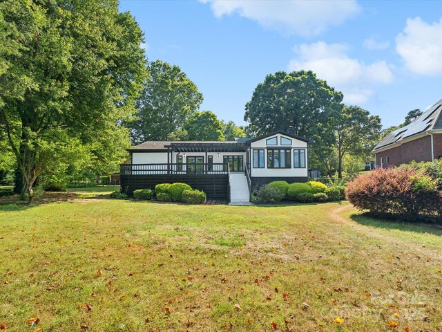 rear view of property with a deck and a lawn