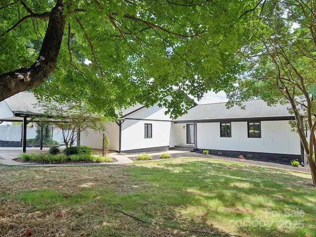 view of front of property featuring crawl space, a shingled roof, and a front lawn