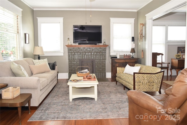 living room with ornamental molding, a wealth of natural light, wood finished floors, and a fireplace