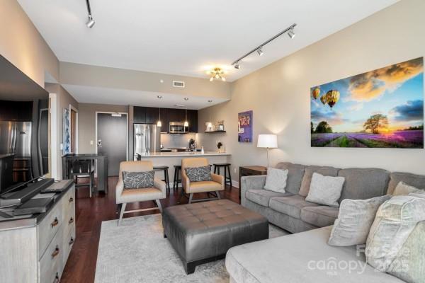 45 Asheland Ave Unit 500, Asheville, NC 28801 - living area with rail lighting, visible vents, and wood finished floors