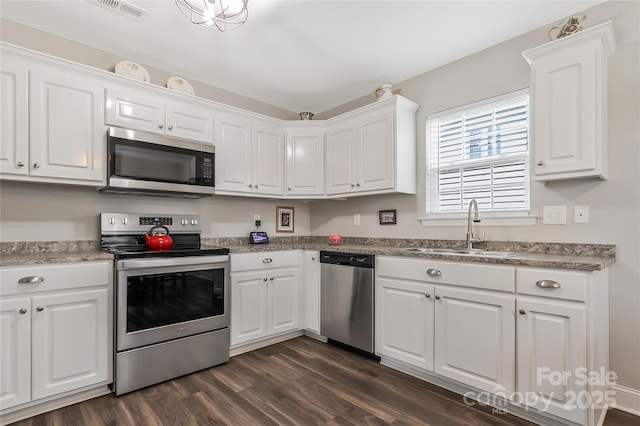 kitchen featuring a sink, white cabinets, appliances with stainless steel finishes, and dark wood-style flooring