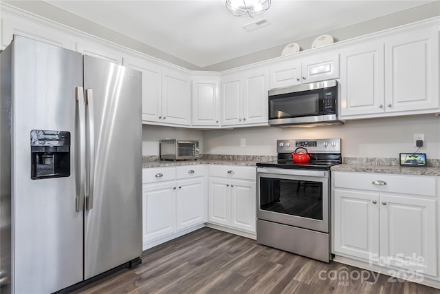 kitchen with dark wood-style floors, visible vents, stainless steel appliances, and white cabinets