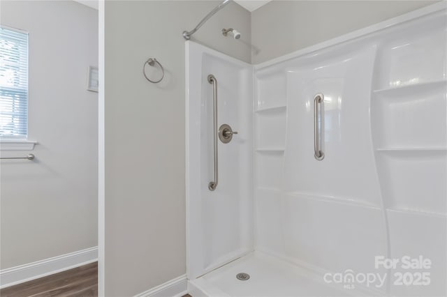 bathroom featuring a shower, baseboards, and wood finished floors