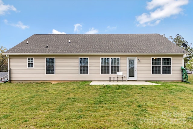 back of property featuring a patio, roof with shingles, and a yard