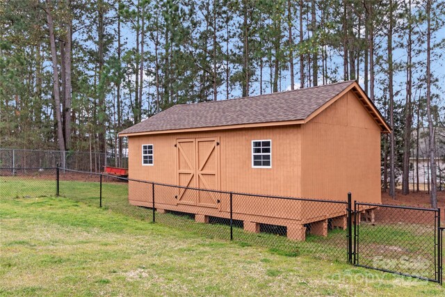 view of outdoor structure featuring a gate, an outdoor structure, and fence