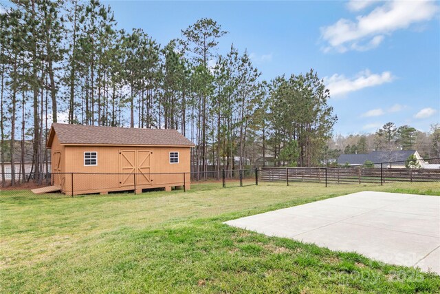 view of yard with an outbuilding, a fenced backyard, and a shed