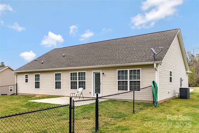 back of house featuring fence, a shingled roof, a yard, and a patio
