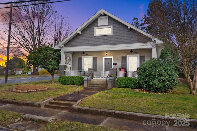 view of front of house with a porch, a yard, and ceiling fan