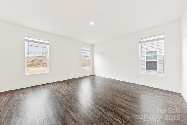 unfurnished room with dark wood finished floors and baseboards