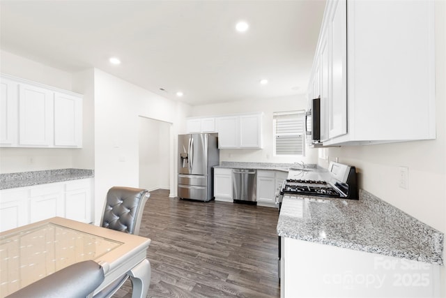 kitchen with light stone counters, white cabinetry, stainless steel appliances, recessed lighting, and dark wood-style flooring