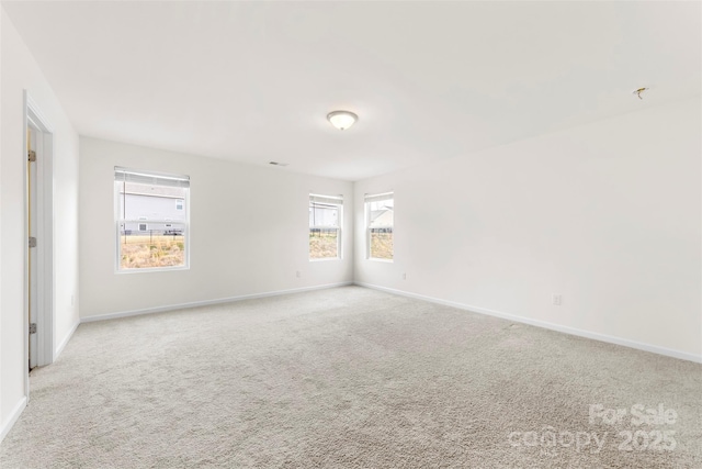 spare room with baseboards and carpet