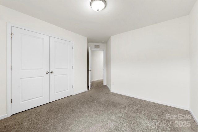 unfurnished bedroom featuring a closet, baseboards, visible vents, and carpet