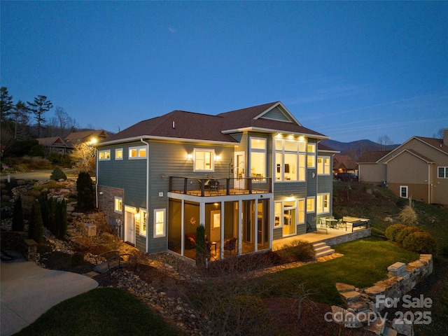 rear view of property featuring a lawn and a patio area