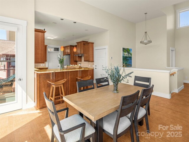 dining area with baseboards and light wood-type flooring