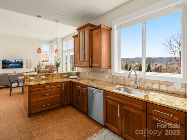 kitchen with a sink, dishwasher, a peninsula, glass insert cabinets, and brown cabinets