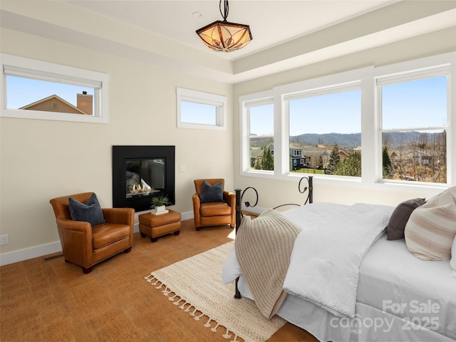 bedroom featuring light wood-style floors, baseboards, and a mountain view