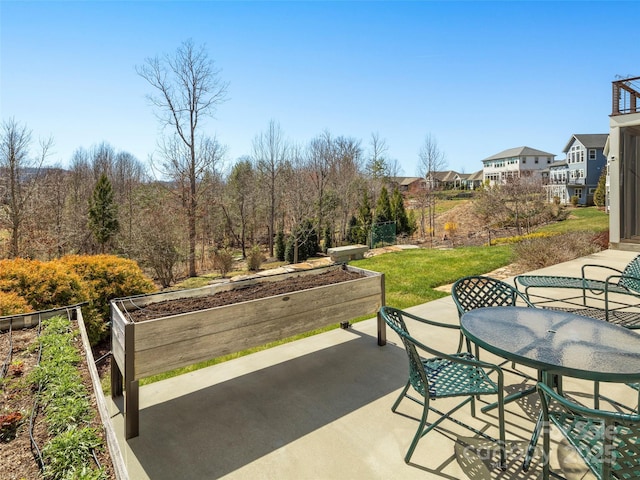 view of patio featuring outdoor dining space and a vegetable garden
