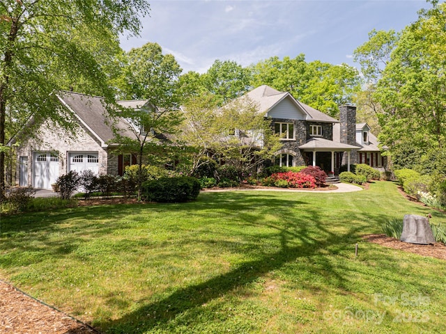 421 N Boundary Rd, Mill Spring, NC 28756 - rear view of house with stone siding, a lawn, a chimney, and an attached garage