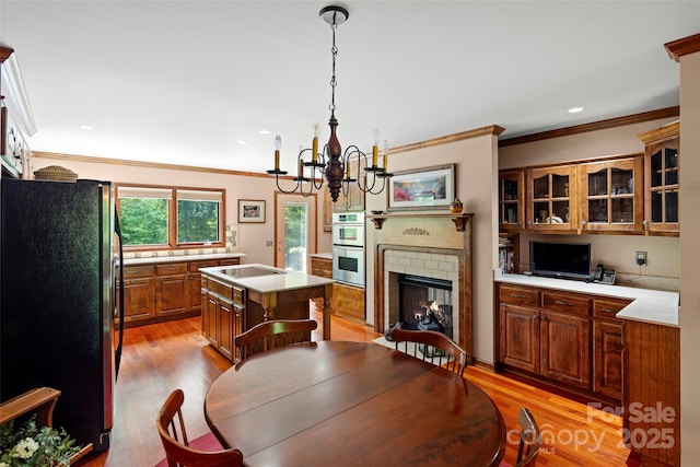 421 N Boundary Rd, Mill Spring, NC 28756 - dining space featuring crown molding, light wood-style flooring, a chandelier, a brick fireplace, and recessed lighting