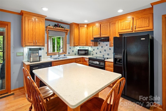 421 N Boundary Rd, Mill Spring, NC 28756 - kitchen with black appliances, a sink, light countertops, a breakfast bar area, and crown molding