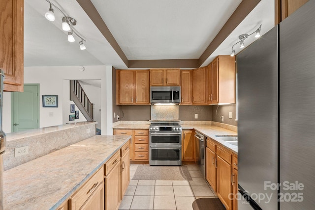 kitchen featuring light stone countertops, appliances with stainless steel finishes, and light tile patterned floors