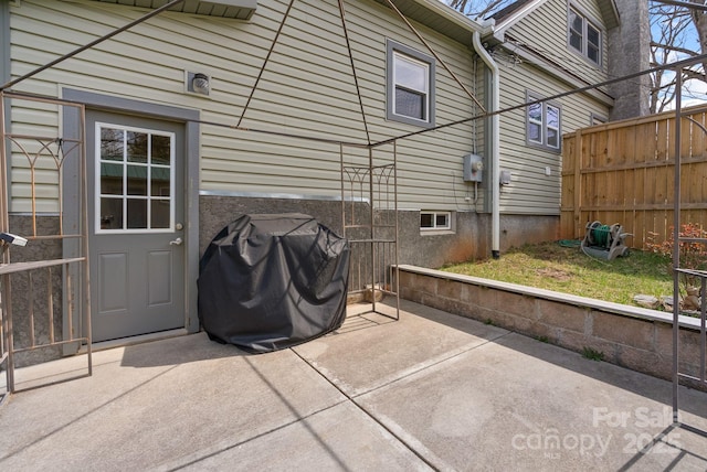 view of patio featuring area for grilling and fence