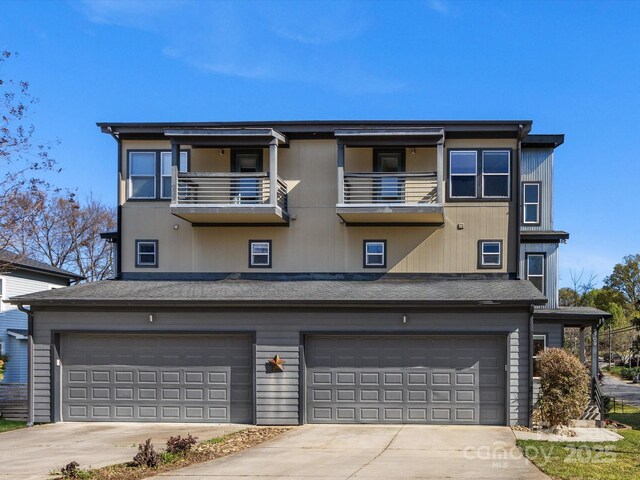 multi unit property featuring an attached garage, a balcony, and driveway