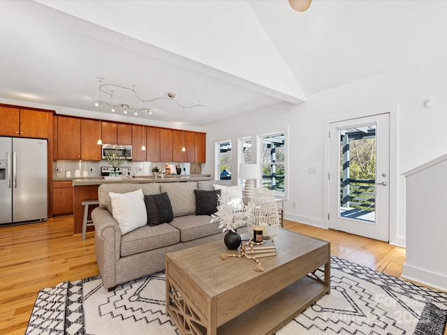 living room featuring light wood-style floors, baseboards, and a healthy amount of sunlight