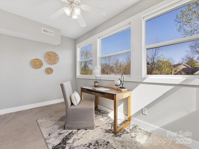 office space featuring baseboards, carpet, a ceiling fan, and visible vents