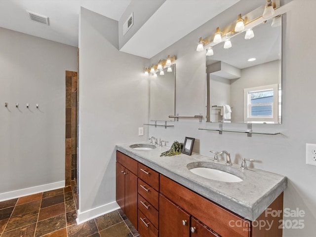 bathroom featuring a sink, baseboards, and visible vents