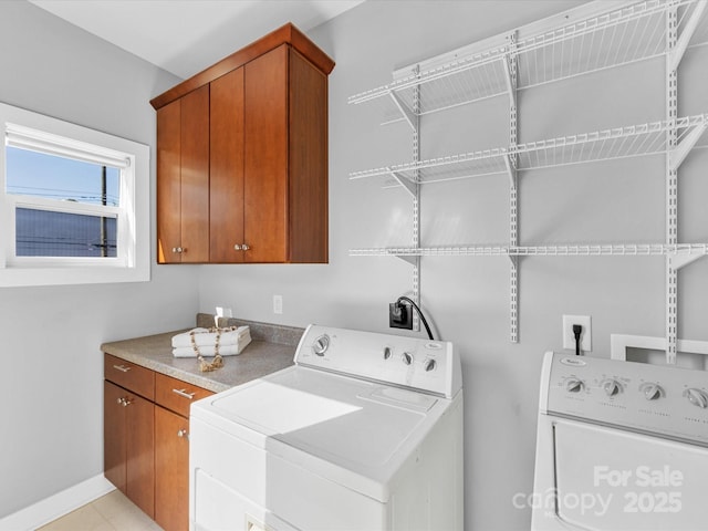 laundry room featuring baseboards, cabinet space, and washer and dryer