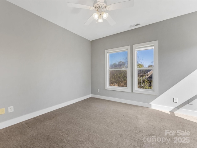 spare room with carpet flooring, baseboards, visible vents, and ceiling fan