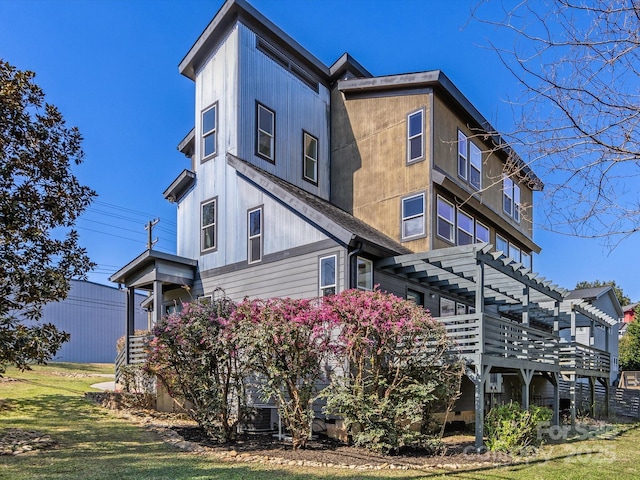 view of side of home with a yard and a pergola