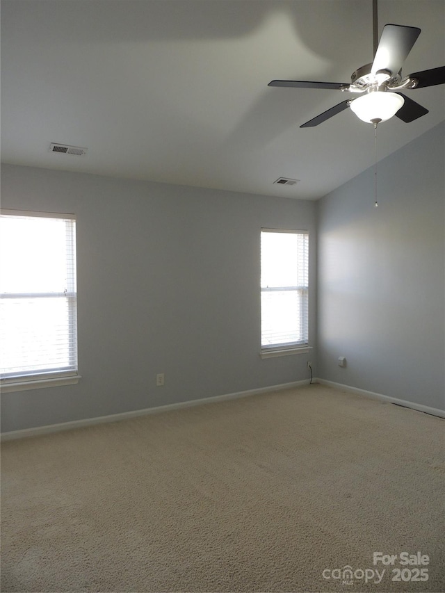 empty room with light colored carpet, baseboards, ceiling fan, and visible vents