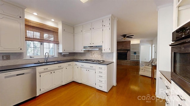 116 Jonas Dr, Lincolnton, NC 28092 - kitchen featuring under cabinet range hood, a sink, dark countertops, appliances with stainless steel finishes, and a fireplace