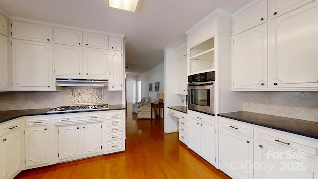 116 Jonas Dr, Lincolnton, NC 28092 - kitchen with white cabinetry, under cabinet range hood, dark countertops, light wood finished floors, and appliances with stainless steel finishes
