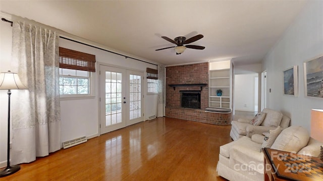116 Jonas Dr, Lincolnton, NC 28092 - living area with visible vents, a brick fireplace, wood finished floors, a ceiling fan, and french doors