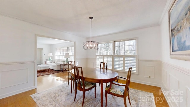 116 Jonas Dr, Lincolnton, NC 28092 - dining space with a decorative wall, light wood-style flooring, crown molding, an inviting chandelier, and wainscoting