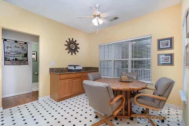 dining space with ceiling fan, light floors, and baseboards