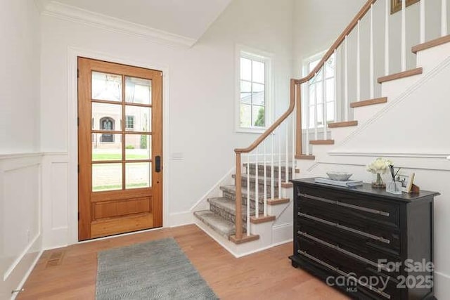 3119 Knowlton Ln, Charlotte, NC 28205 - entryway featuring stairs, ornamental molding, wood finished floors, and a wainscoted wall