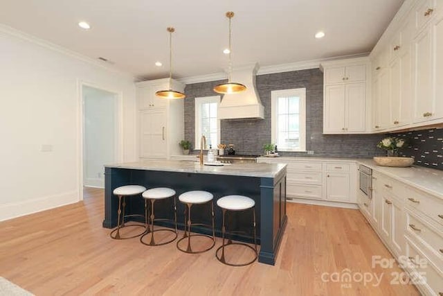 3119 Knowlton Ln, Charlotte, NC 28205 - kitchen featuring custom exhaust hood, stainless steel microwave, crown molding, white cabinetry, and light countertops