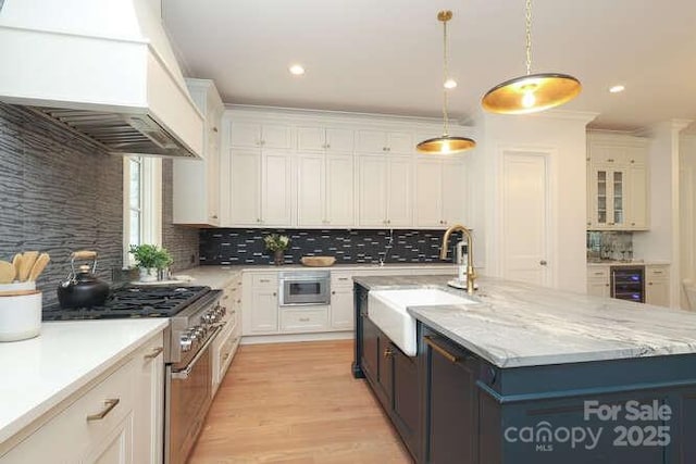 3119 Knowlton Ln, Charlotte, NC 28205 - kitchen with appliances with stainless steel finishes, a sink, beverage cooler, custom exhaust hood, and white cabinetry