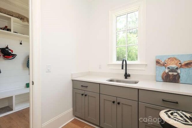 3119 Knowlton Ln, Charlotte, NC 28205 - kitchen with gray cabinetry, a sink, light countertops, light wood finished floors, and baseboards