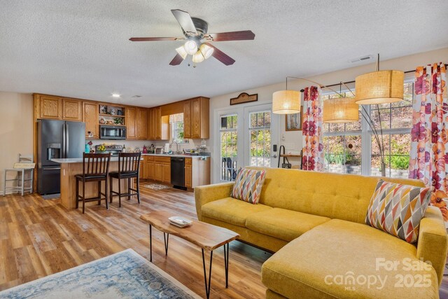 12 Hutchinson Woods Dr, Fletcher, NC 28732 - living room featuring visible vents, a textured ceiling, light wood-style floors, and ceiling fan