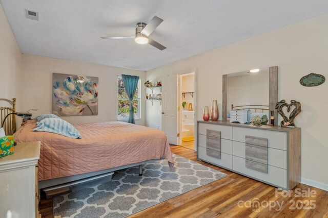 12 Hutchinson Woods Dr, Fletcher, NC 28732 - bedroom featuring wood finished floors, visible vents, baseboards, ceiling fan, and ensuite bathroom